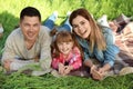 Happy family lying on green grass in park Royalty Free Stock Photo