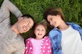 Happy family lying on green grass in park Royalty Free Stock Photo