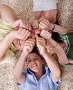 Happy family lying and showing thumps up together Royalty Free Stock Photo