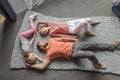 Happy family lying together on grey knitted carpet