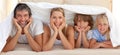 Happy family lying under a blanket Royalty Free Stock Photo