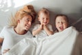 Happy family lying under white blanket in the morning. Royalty Free Stock Photo