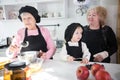 Happy family making pancake in the kitchen. Apples on the table Royalty Free Stock Photo