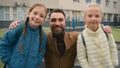 Happy family man two girls dad daughters schoolgirls students primary school together love support parent smiling cuddle Royalty Free Stock Photo