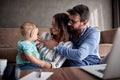 Happy family-man and woman spending happy time at home with their baby son and playing together. Royalty Free Stock Photo