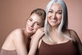 Happy family, mature mother, adult daughter embracing smiling looking at camera Royalty Free Stock Photo