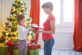 Happy family and Merry Christmas. Mother and baby son at Christmas morning at tree Royalty Free Stock Photo