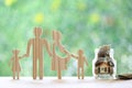 Happy family with model house and gold coin money in the glass bottle on natural green background, Save money for prepare in Royalty Free Stock Photo