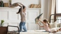 Happy mom and kid daughter having pillow fight on bed Royalty Free Stock Photo