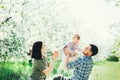 Happy family mom dad and baby daughter having fun outdoor in park smiling and laughing. Lifestyle Emotions Relationship Love