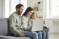 Happy family of mom, dad and cute little daughter sitting at laptop at home Royalty Free Stock Photo
