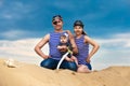 Happy family, mom, dad and little son in striped vests having fun in the sand outdoors against blue sky background. Summer Royalty Free Stock Photo