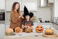 Happy family: mom and daughter celebrate Halloween. Merry child in witch carnival costume in the room. Cheerful kid and Royalty Free Stock Photo