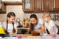 Happy family mom and daughters are cooking birthday cake together. Royalty Free Stock Photo