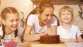 Happy family mom and daughters are cooking birthday cake together. Royalty Free Stock Photo