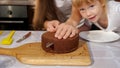 Happy family mom and daughters are cooking birthday cake together. Royalty Free Stock Photo