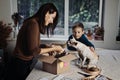 Happy family mom and kid putting bone in Pet Subscription Box for Dogs. Chihuahua dog and Subscription pet box with Royalty Free Stock Photo