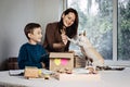 Happy family mom and kid putting bone in Pet Subscription Box for Dogs. Chihuahua dog and Subscription pet box with Royalty Free Stock Photo
