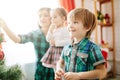 Happy family mom, son and daughter on a Christmas winter sunny morning in a decorated Christmas celebration room with a Royalty Free Stock Photo