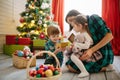 Happy family mom, son and daughter on a Christmas winter sunny morning in a decorated Christmas celebration room with a Royalty Free Stock Photo