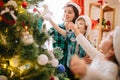 Happy family mom, son and daughter on a Christmas winter sunny morning in a decorated Christmas celebration room with a Royalty Free Stock Photo