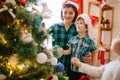 Happy family mom, son and daughter on a Christmas winter sunny morning in a decorated Christmas celebration room with a Royalty Free Stock Photo