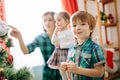 Happy family mom, son and daughter on a Christmas winter sunny morning in a decorated Christmas celebration room with a Royalty Free Stock Photo