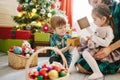 Happy family mom, son and daughter on a Christmas winter sunny morning in a decorated Christmas celebration room with a Royalty Free Stock Photo