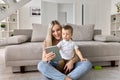 Happy family mom teaching cute child son using digital tablet at home. Royalty Free Stock Photo