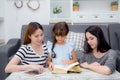 happy family mother, aunt, freind and daughter teaching read a book. Royalty Free Stock Photo