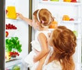 Happy family mother and baby daughter drinking orange juice in Royalty Free Stock Photo