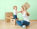 Happy family mother and baby daughter in an empty apartment with cardboard boxes Royalty Free Stock Photo