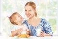 Happy family mother and baby daughter girl at breakfast: biscuit Royalty Free Stock Photo