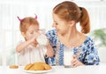 Happy family mother and baby daughter girl at breakfast: biscuit Royalty Free Stock Photo