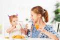 Happy family mother and baby daughter girl at breakfast: biscuit Royalty Free Stock Photo