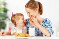 Happy family mother and baby daughter girl at breakfast: biscuit Royalty Free Stock Photo