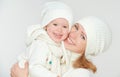 Happy family: mother and baby daughter in white winter hats laughing Royalty Free Stock Photo