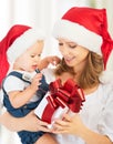 Happy family mother and baby with gift in Christmas hats Royalty Free Stock Photo
