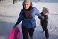 Happy family mother and baby girl daughter playing and laughing in winter outdoors in the snow. Royalty Free Stock Photo