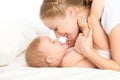 Happy family mother and baby having fun playing, laughing on bed Royalty Free Stock Photo