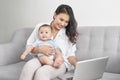 Happy family mother and baby at home using laptop computer Royalty Free Stock Photo