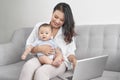 Happy family mother and baby at home using laptop computer Royalty Free Stock Photo