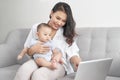 Happy family mother and baby at home using laptop computer Royalty Free Stock Photo