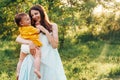 Happy family mother and baby hugging in a meadow during sunset on nature Royalty Free Stock Photo