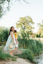 Happy family mother and baby hugging in a meadow during sunset on nature Royalty Free Stock Photo