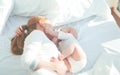 Happy family mother with baby playing and hug in bed Royalty Free Stock Photo