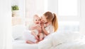 Happy family mother with baby playing and hug in bed Royalty Free Stock Photo