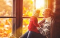 Happy family mother and baby playing and laughing at window in f Royalty Free Stock Photo