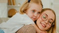 Happy family mother with Caucasian little daughter child girl kid embrace mom by neck piggyback cuddling hugging talking Royalty Free Stock Photo