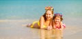 Happy family mother and chid daughter in masks on beach in summer Royalty Free Stock Photo